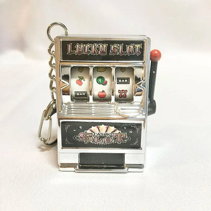 Llavero de moda con juguete mini máquina tragamonedas. Diseño creativo, ideal para auto o como regalo.