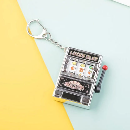 Llavero de moda con juguete mini máquina tragamonedas. Diseño creativo, ideal para auto o como regalo.